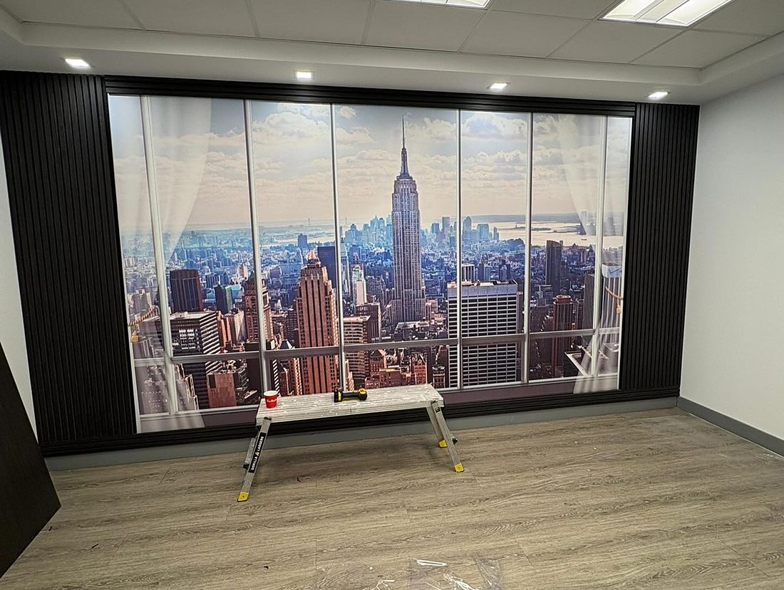 Finished office interior with black slat panelling and a printed wall mural